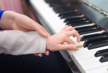 Persona enseñando a tocar el piano