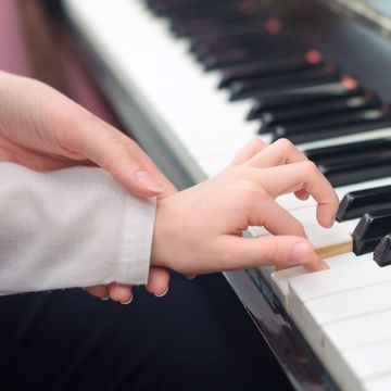 Persona enseñando a tocar el piano